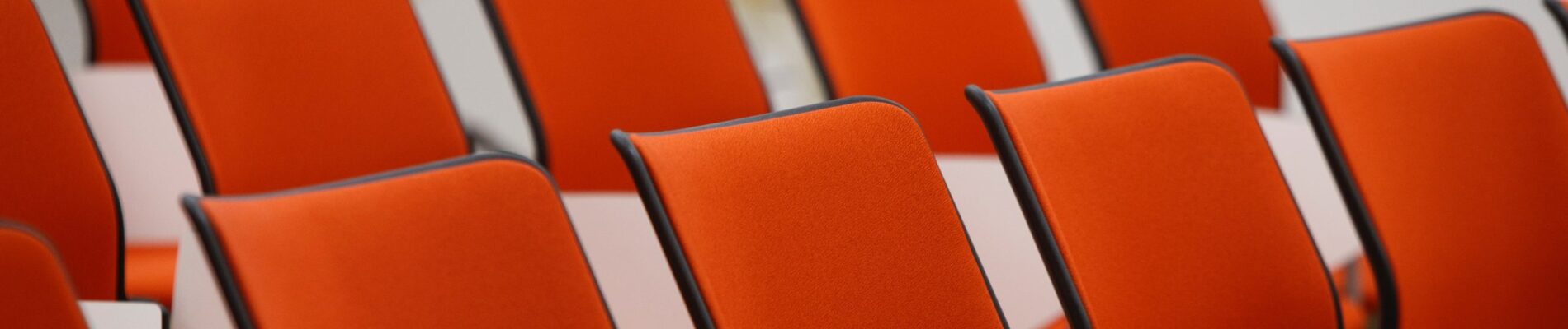 Une rangée de chaises oranges.